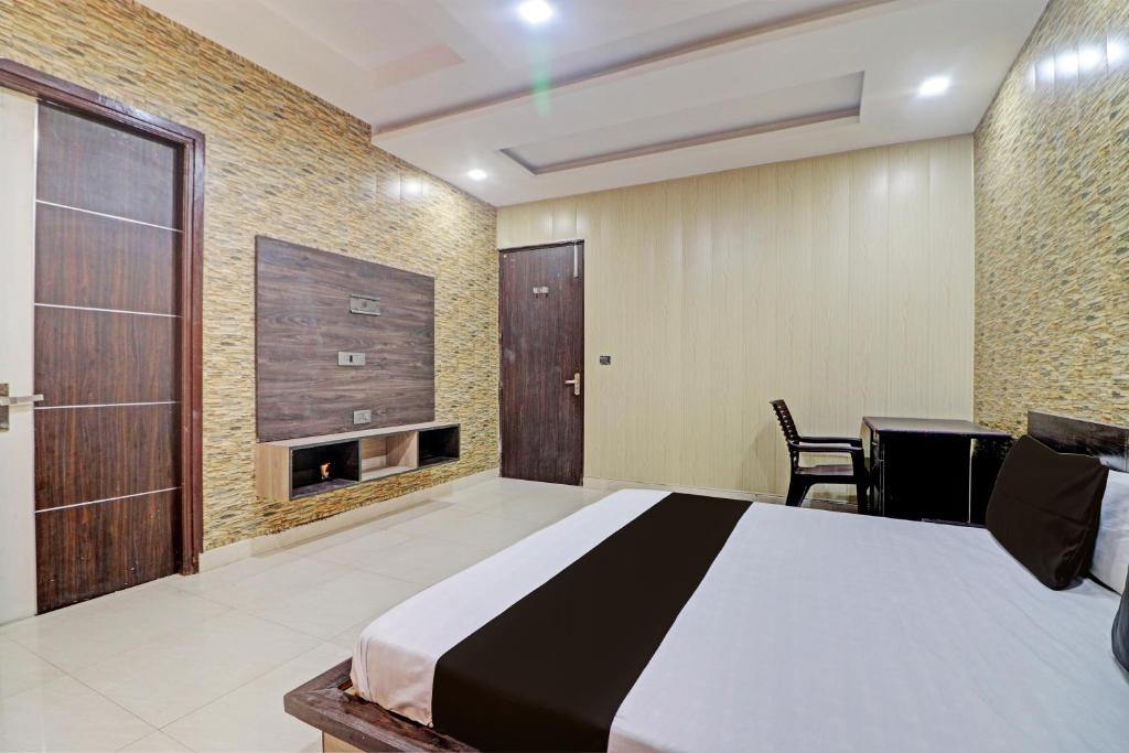 a bedroom with a bed and a table and a fireplace at Grand Townhouse in Palwal