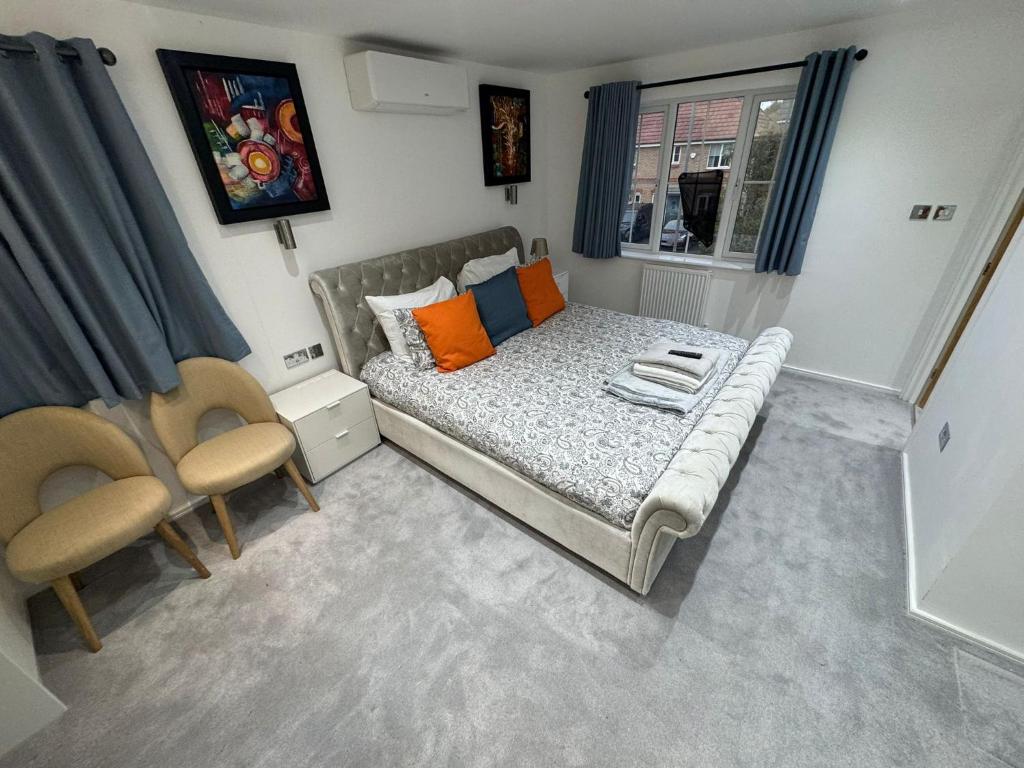 una pequeña habitación con una cama y dos sillas en WBC R1 - Modern Large Ensuite Room - Wednesbury, en Bilston