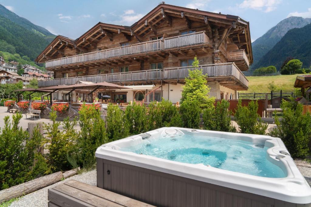 a large hot tub in front of a house at Alpen Chalet - Charme Mountain Hotel - in Schilpario