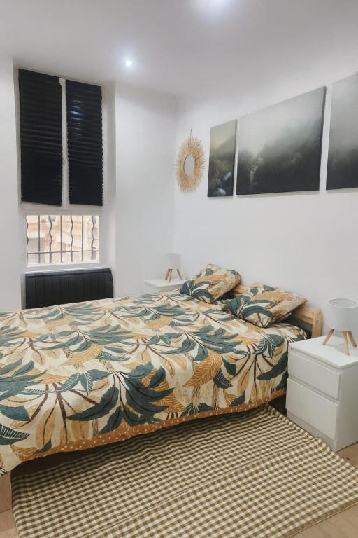 um quarto com uma cama com um edredom colorido em apartamento en el 10 em Paris