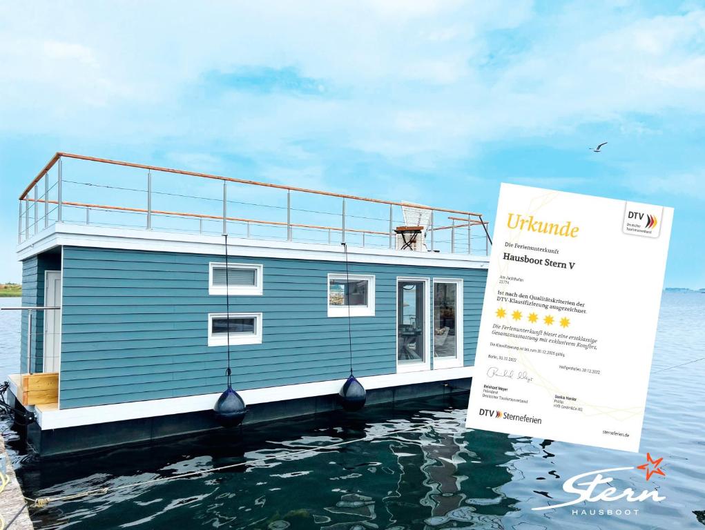 a house on a boat in the water at STERN V Hausboot Heiligenhafen in Heiligenhafen