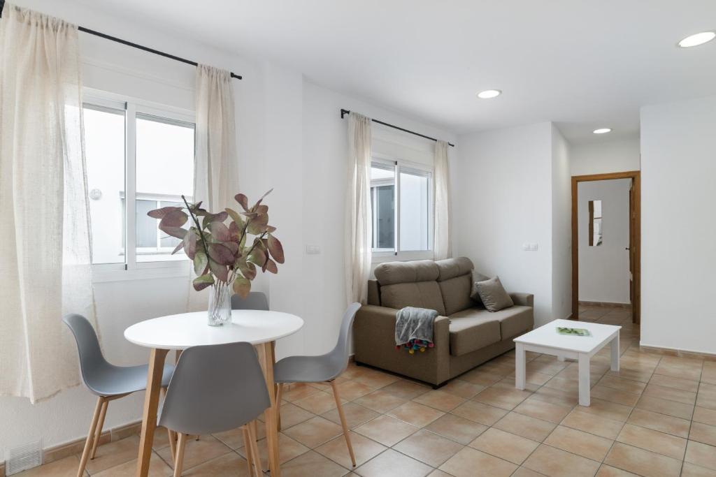 ein Wohnzimmer mit Sofa und Tisch in der Unterkunft Apartamento Perez Zara 3 in Conil de la Frontera