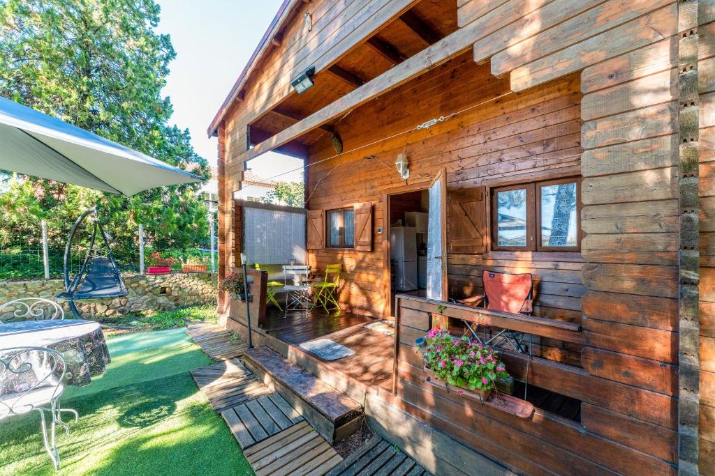 a wooden house with a deck and a patio at Chalet gite in Saint-Paulet-de-Caisson