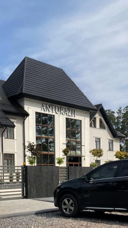 Ein schwarzes Auto parkte vor einem Gebäude in der Unterkunft Anturazh Resort in Brody