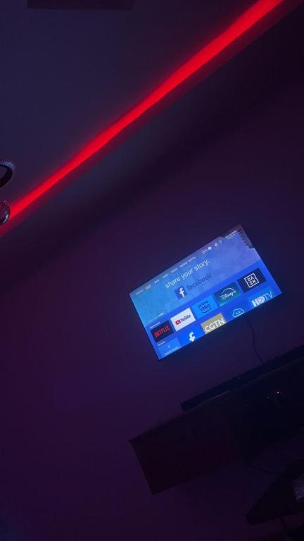 Una luz roja sobre un escenario con un televisor en OA luxury apartment, 