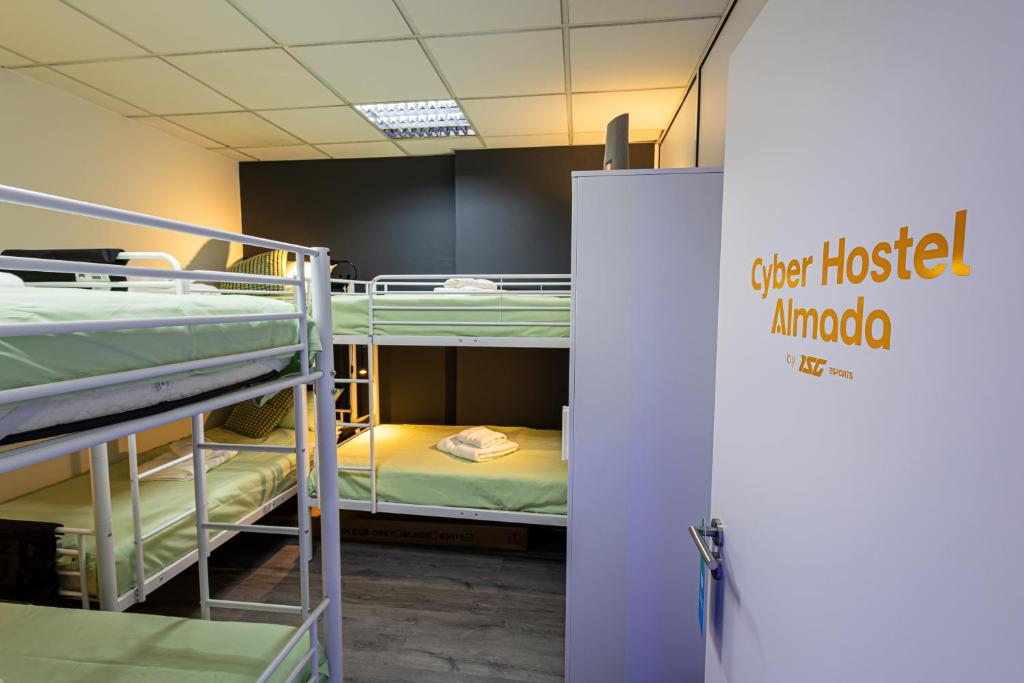 una habitación con literas y un letrero que dice casa de huéspedes Amanda en CyberHostel Almada, en Almada