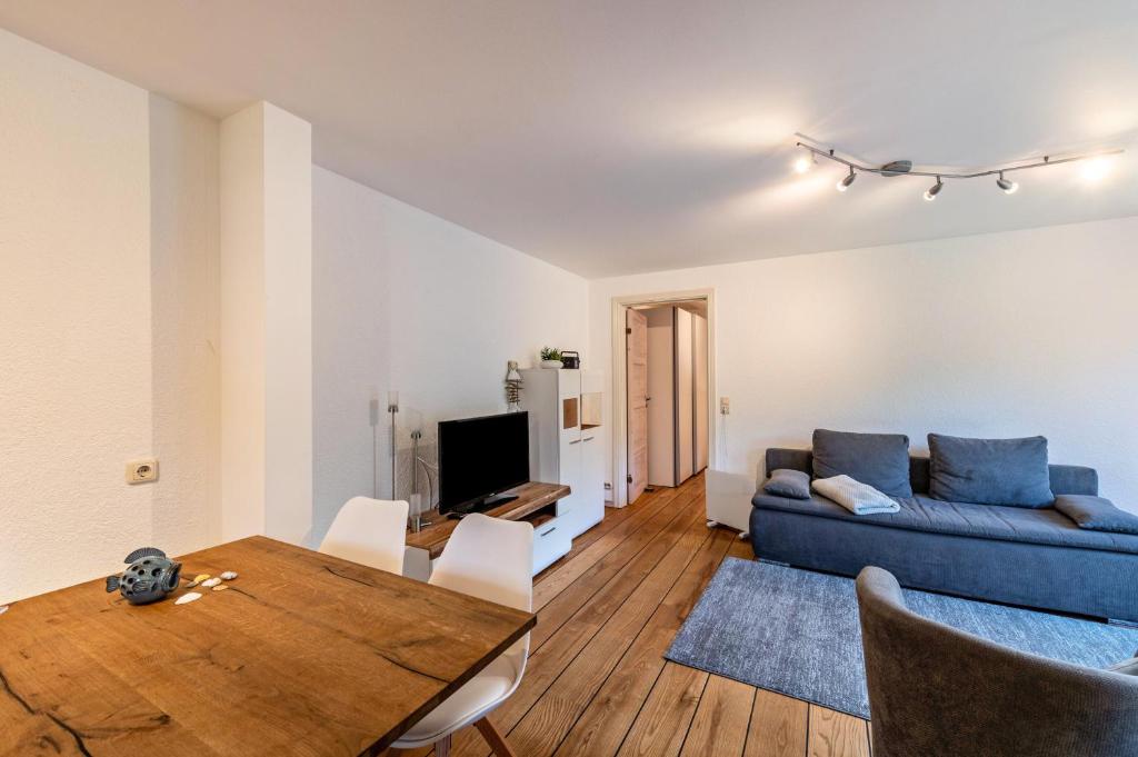 a living room with a blue couch and a table at Strandnahes Ferienhaus in Dierhagen
