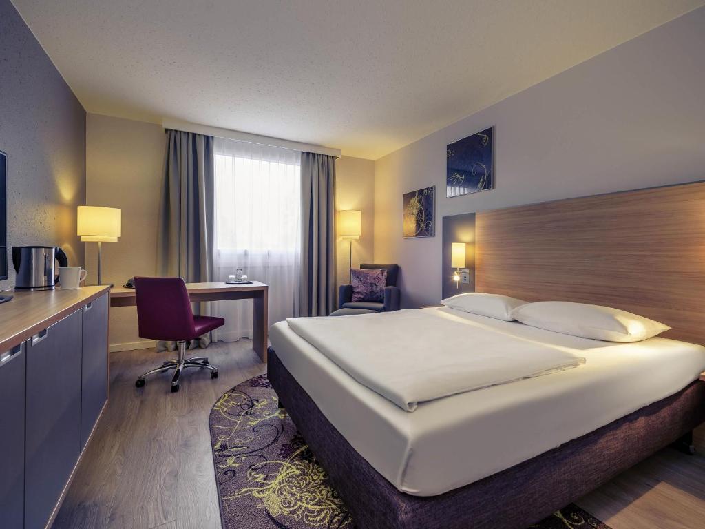 une chambre d'hôtel avec un lit et un bureau dans l'établissement Fürther Hotel Mercure Nürnberg West, à Fürth