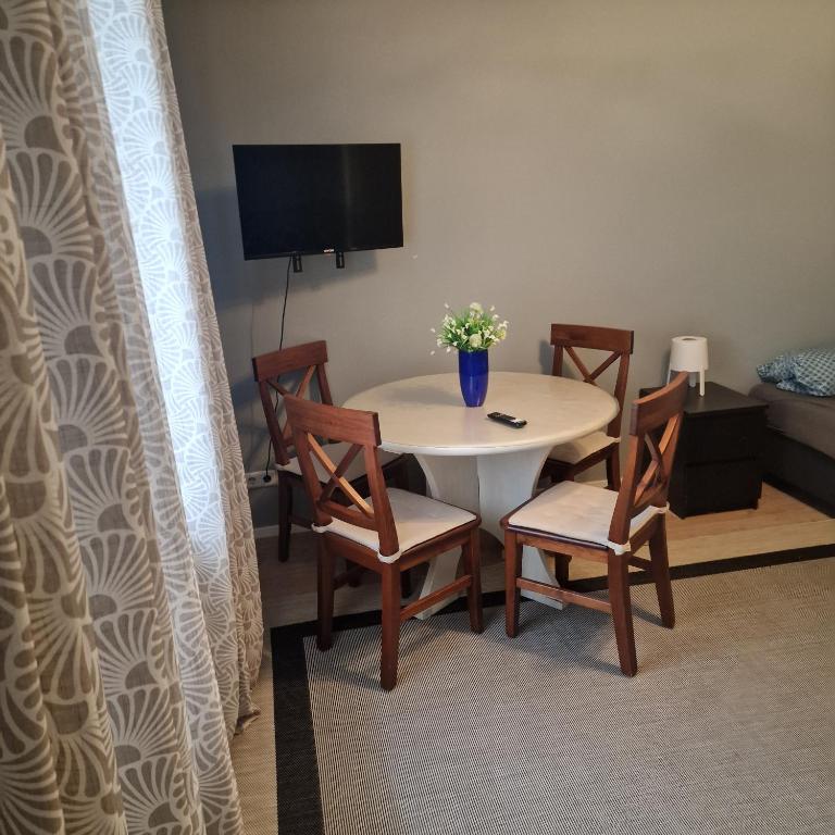 a room with a table and chairs and a television at Rema Ferienwohnungen in Zossen