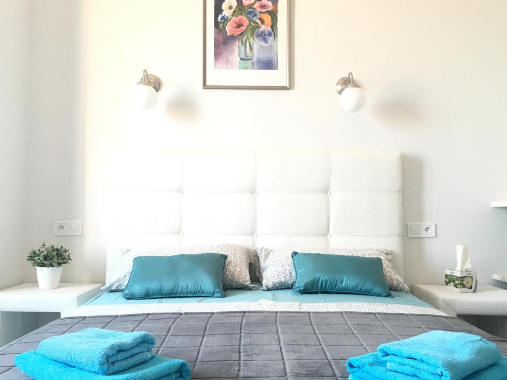 - une chambre avec un lit et des oreillers bleus dans l'établissement Apartments Monaco, à Monte-Carlo