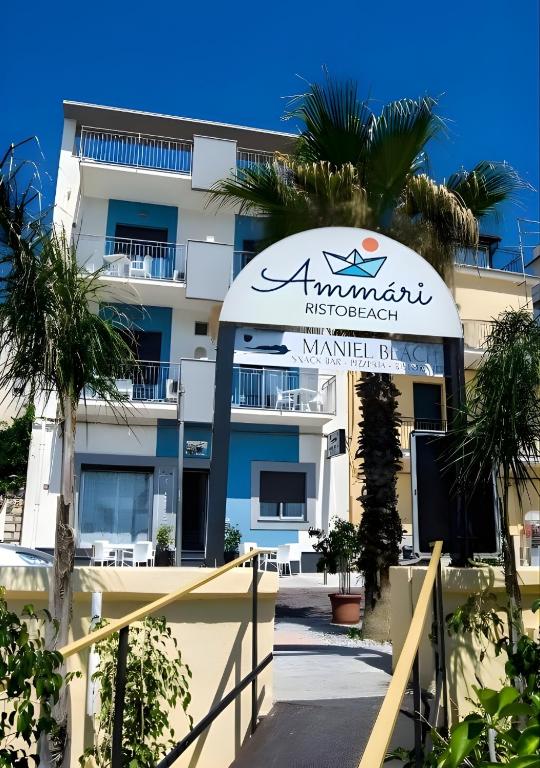 ein Gebäude mit einem Schild davor in der Unterkunft Maniel Beach Hotel in Letojanni