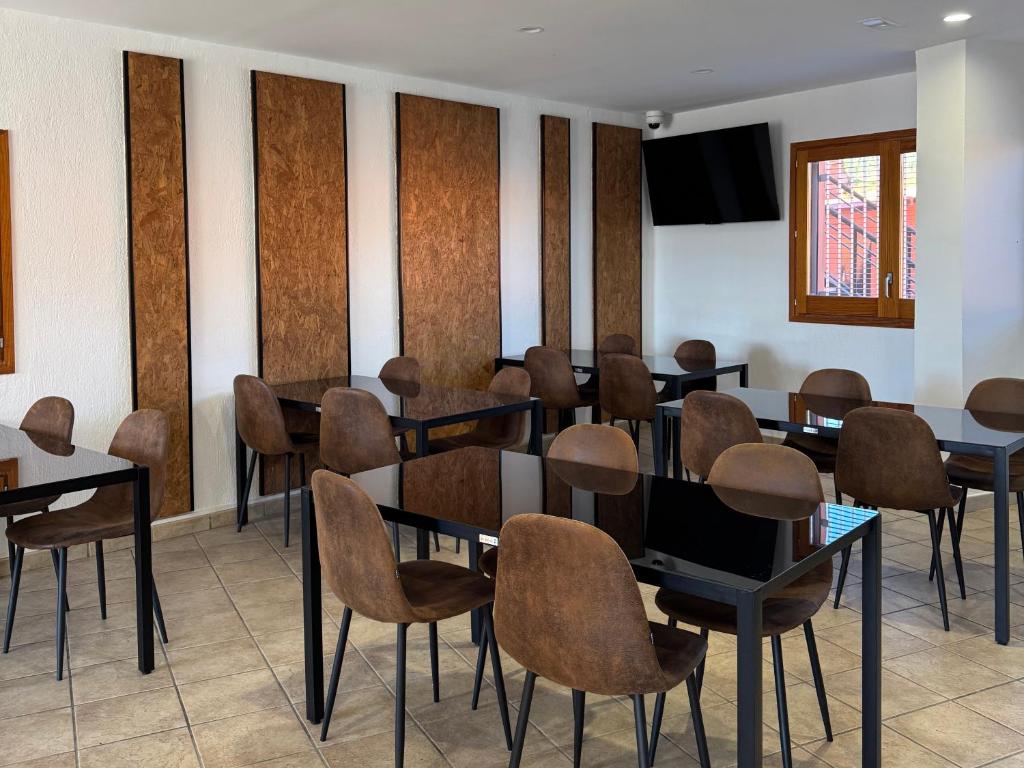 a room with tables and chairs and a television at HOTEL ORENETA - Gironella in Gironella