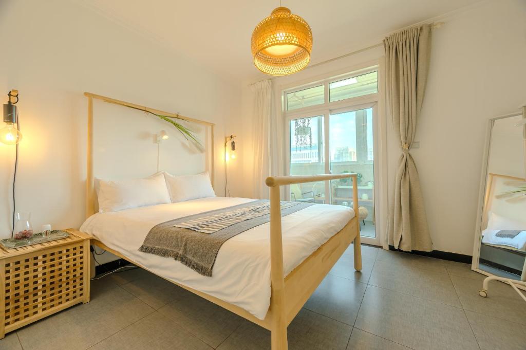ein Schlafzimmer mit einem Bett und einem großen Fenster in der Unterkunft Gongxi Home Plus Bell Tower Big Wild Goose Pagoda Tangcheng Terra Cotta Warriors6 metro away from Xian North Railway Station 3 minutes walk to Line 2 100 inch projection free trial service in Xi'an