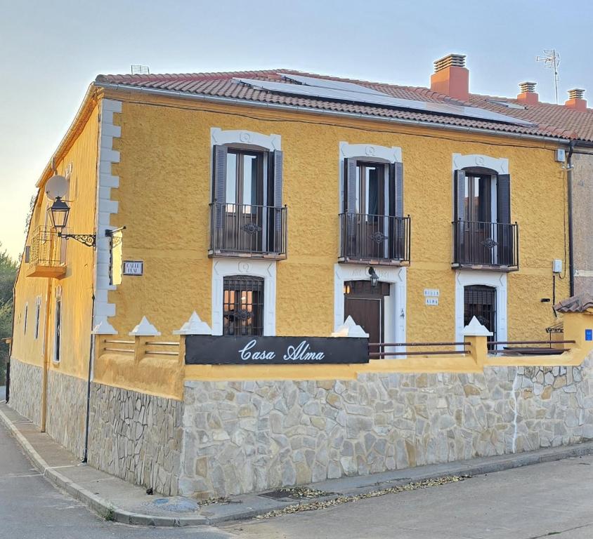 a yellow building on the side of a street at Villa Rural Casa Alma in Castiltierra