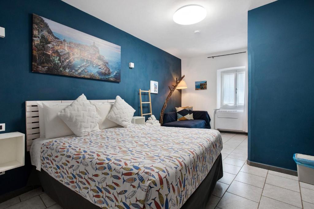 une chambre avec un lit et un mur bleu dans l'établissement Ca Du Grifun 2, à Vernazza
