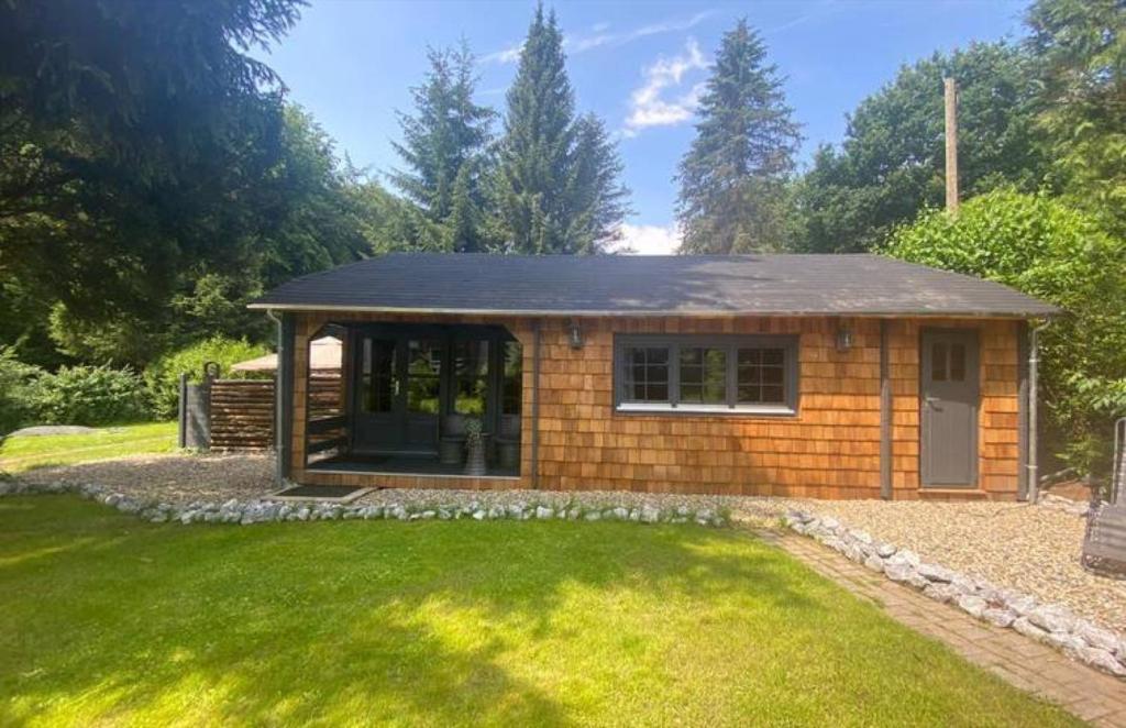 ErmetheisWeißenthalsmühle Eichenhäuschen的一座小房子,位于一个绿色草坪的庭院内