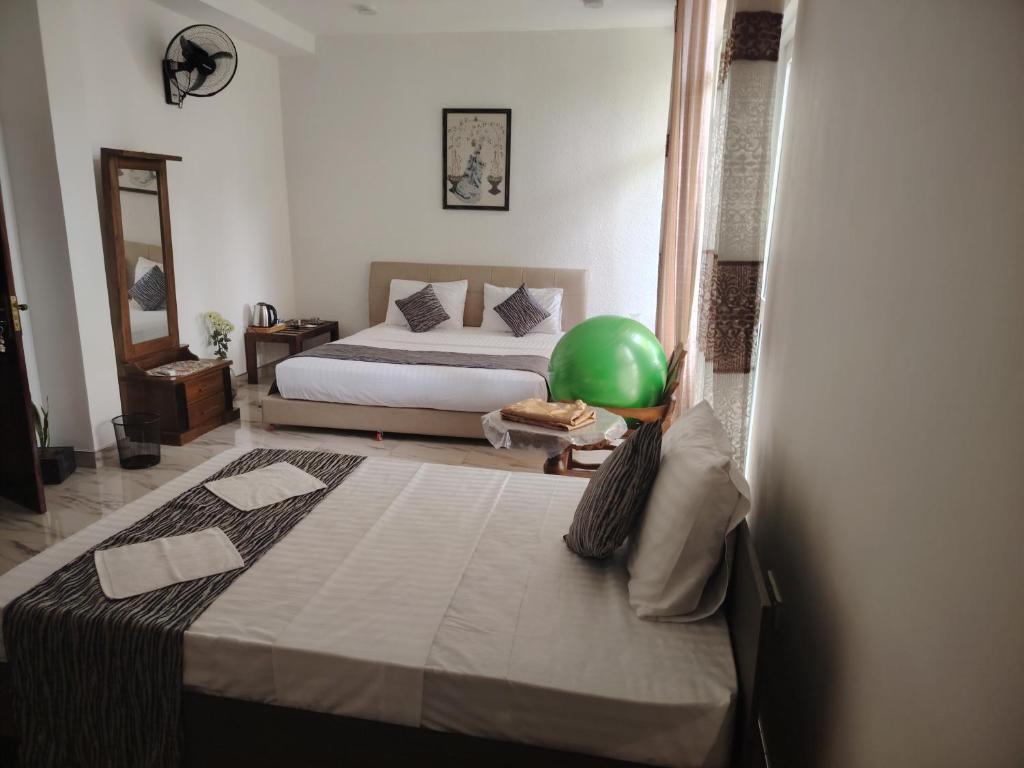 a bedroom with a bed with a green ball on it at Charlotte Inn in Kandy