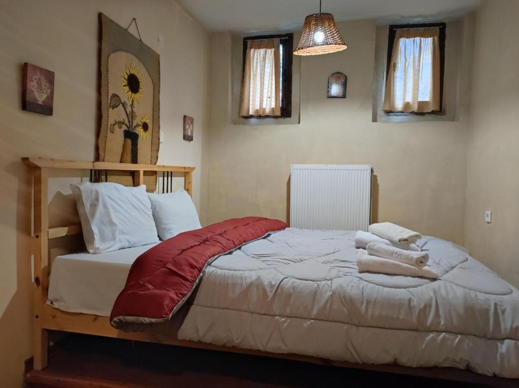 a bedroom with a bed with a red blanket at Villa Aretousa in Palaios Agios Athanasios