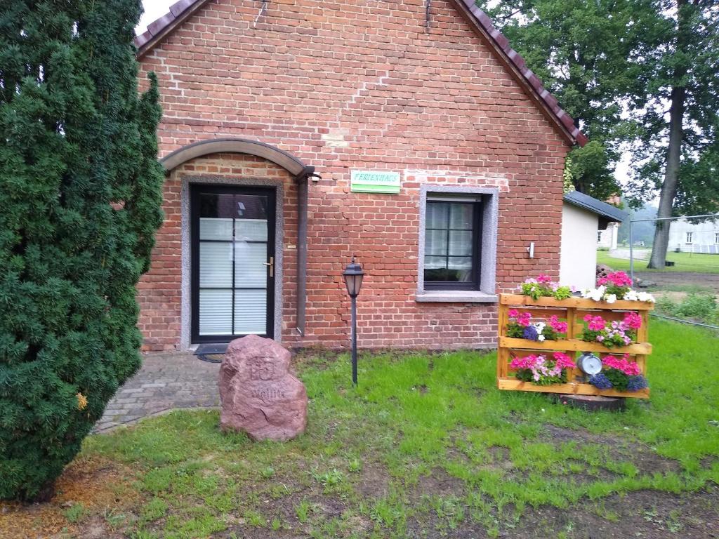 a brick house with a bunch of flowers in the yard at Ferienhäuschen in der Nähe der Kirche in Rheinsberg