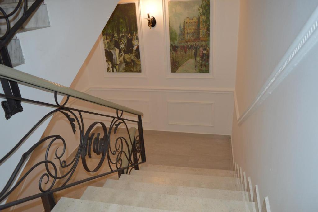 
a staircase leading up to a balcony with a painting on the wall at Vila Ada Hotel in Tirana
