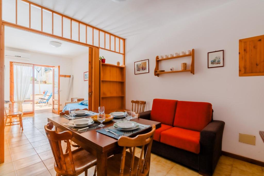 a living room with a table and a red couch at Casa vacanze Cecilia a Otranto in Otranto
