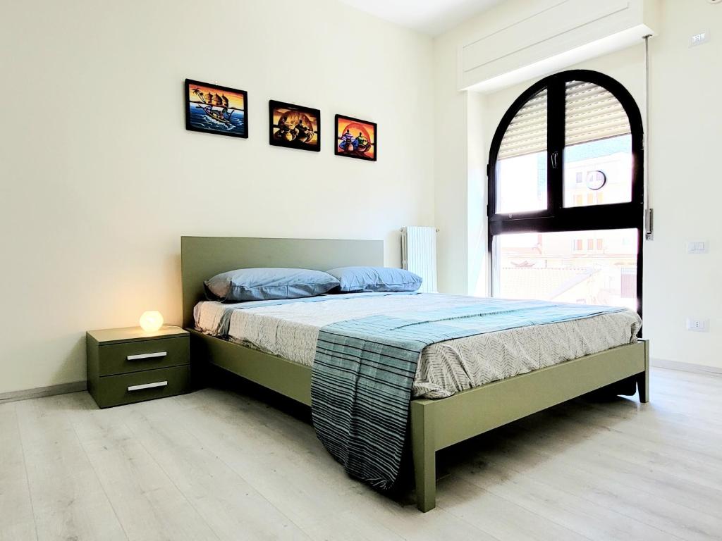 Un dormitorio con una cama y una ventana arqueada. en Casa Mary, en Nocera Inferiore