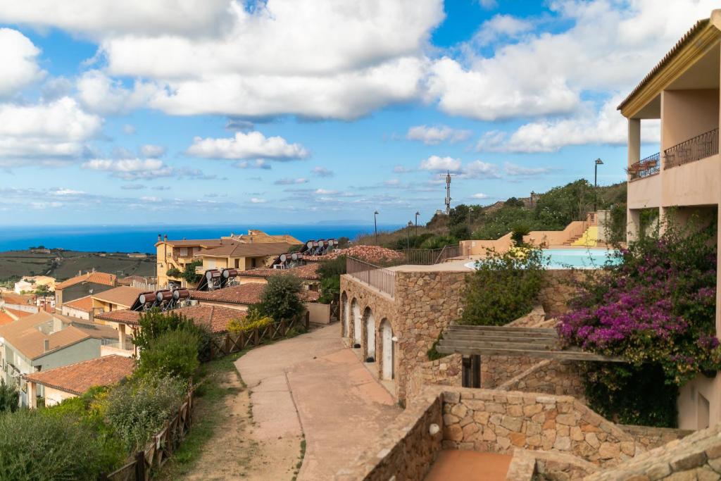 a view of a town with the ocean in the background at Appartamento con piscina 14 in Trinità dʼAgultu