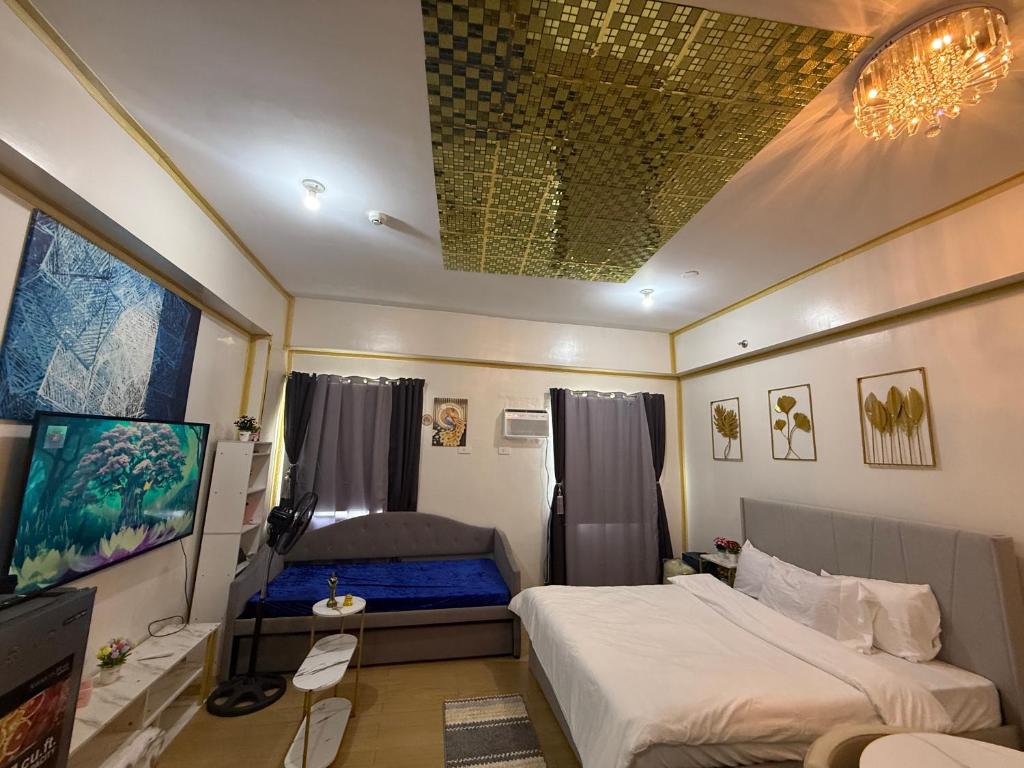 een slaapkamer met 2 bedden en een tv. bij HOPE RESIDENCES UNIT 606 building D in Trece Martires