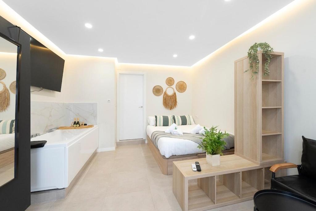 a white bedroom with a bed and a desk at Málaga EXCLUSIVE Apartment Jacuzzi - by N&N LUXE PROPERTIES in Málaga