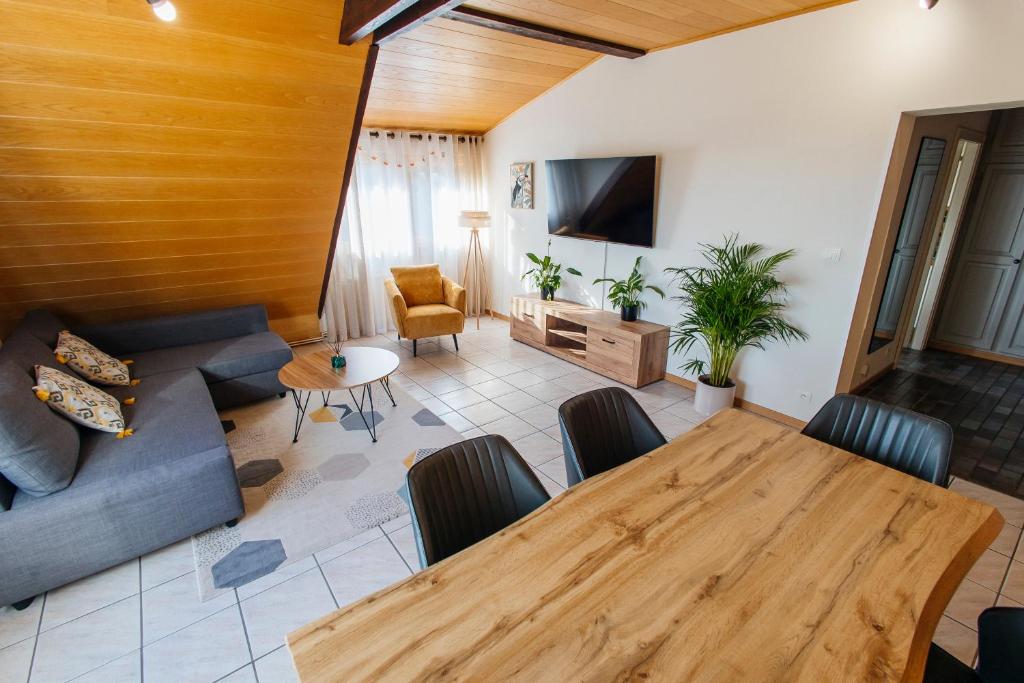 a living room with a wooden table and a couch at Rayon du Soleil in Wintzenheim