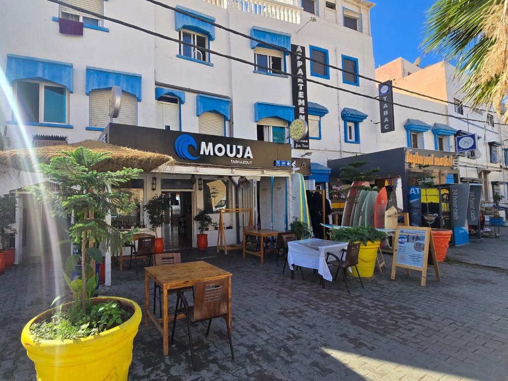 a street with tables and chairs in front of a building at mouja taghazout in Taghazout