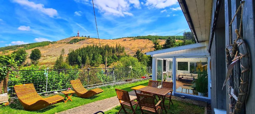 un patio con sillas, una mesa y una montaña en Ferienwohnung Traumblick, en Bestwig