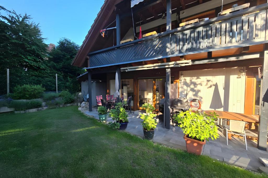 a house with potted plants in front of it at Ferienwohnung Casa Karin mit Sauna in Bodman-Ludwigshafen