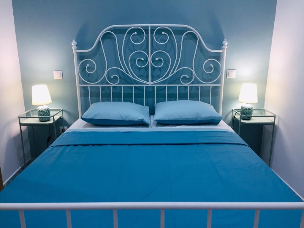 een blauw bed met een metalen hoofdeinde en twee nachtkastjes bij The Loft Malaga Center in Málaga