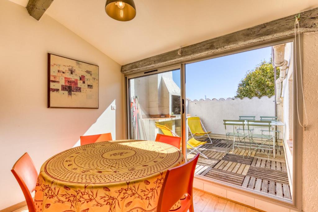 a dining room with a table and chairs and a balcony at Siesta Sete in Sète