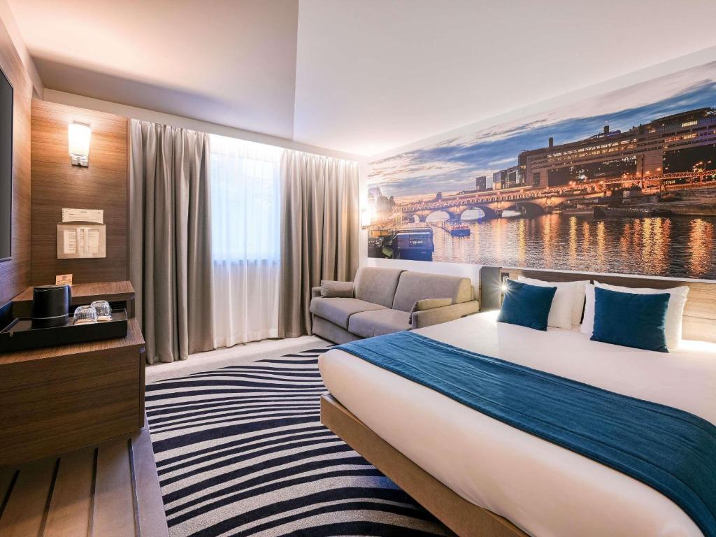a hotel room with a large bed and a couch at Novotel Paris Centre Bercy in Paris