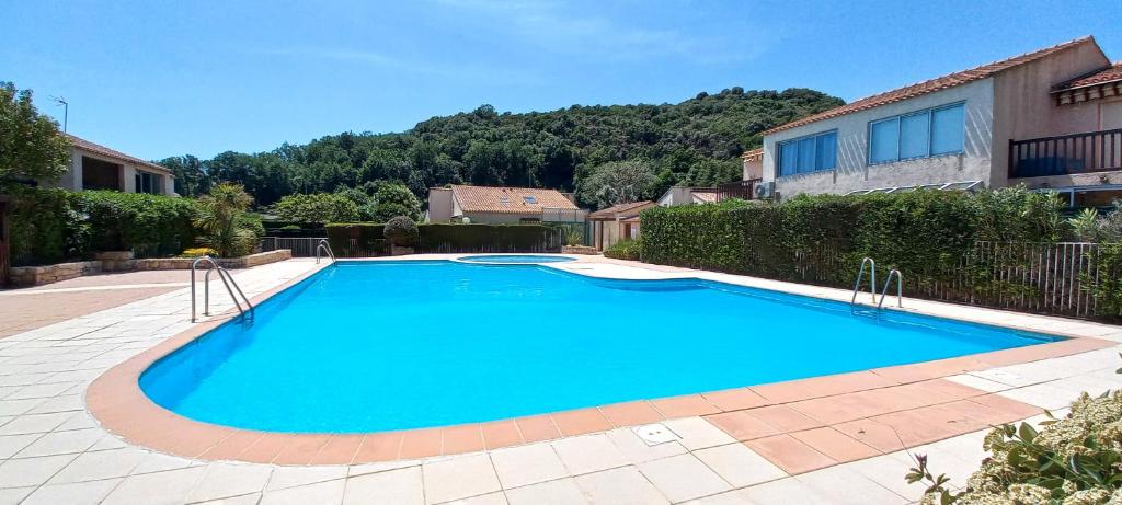 una grande piscina blu davanti a una casa di Coconhut Studio - Terrace - Pool a Villeneuve-Loubet