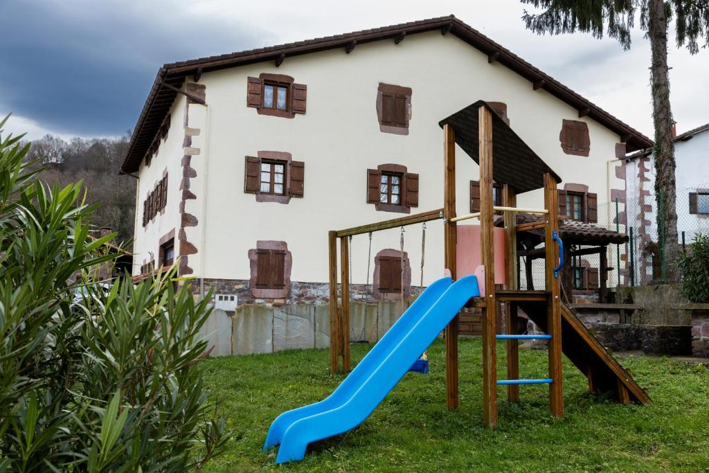 a playground with a slide in front of a house at Matxingonea 1 in Urdax