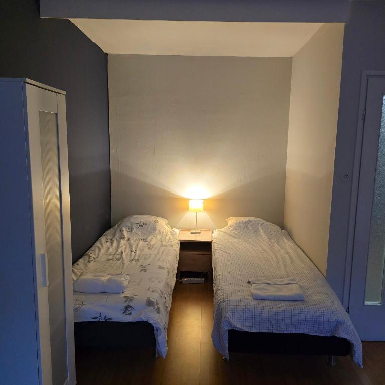 ein kleines Zimmer mit 2 Betten und einem Tisch mit einer Lampe in der Unterkunft Kodikas yksiö Heinolan keskustassa in Heinola