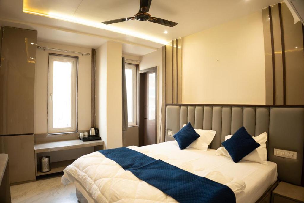 ein Schlafzimmer mit einem großen Bett und blauen Kissen in der Unterkunft Jagrit a Boutique stay in Varanasi