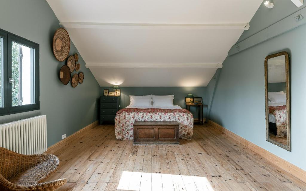 a bedroom with a bed and a wooden floor at Domaine de charme pres de Contis in Saint-Julien-en-Born