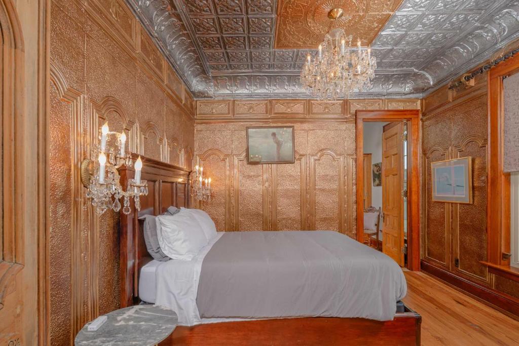 a bedroom with a bed and a chandelier at Dancing Moon Luxury Loft and Event Space - Sleeps 12 in Oshkosh