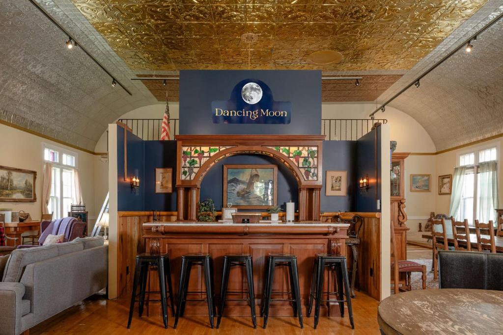 Una barra en un restaurante con taburetes alrededor. en Dancing Moon Luxury Loft and Event Space - Sleeps 12, en Oshkosh