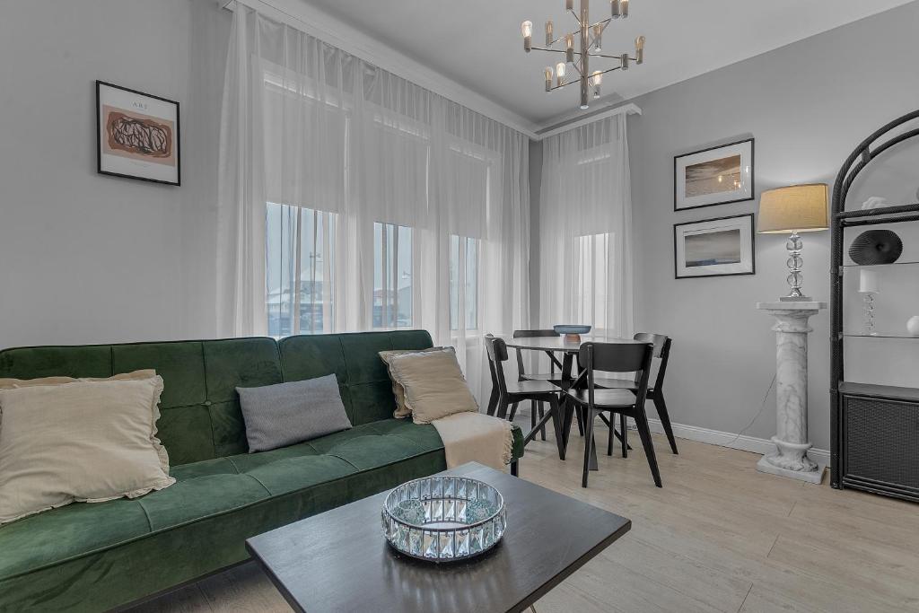 a living room with a green couch and a table at Castle Inn Apartments - Downtown Keflavík in Keflavík
