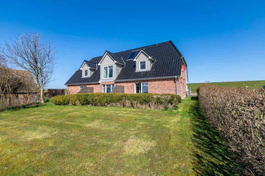 a large brick house with a black roof at Haus Am Meer Familie Frener in Pellworm