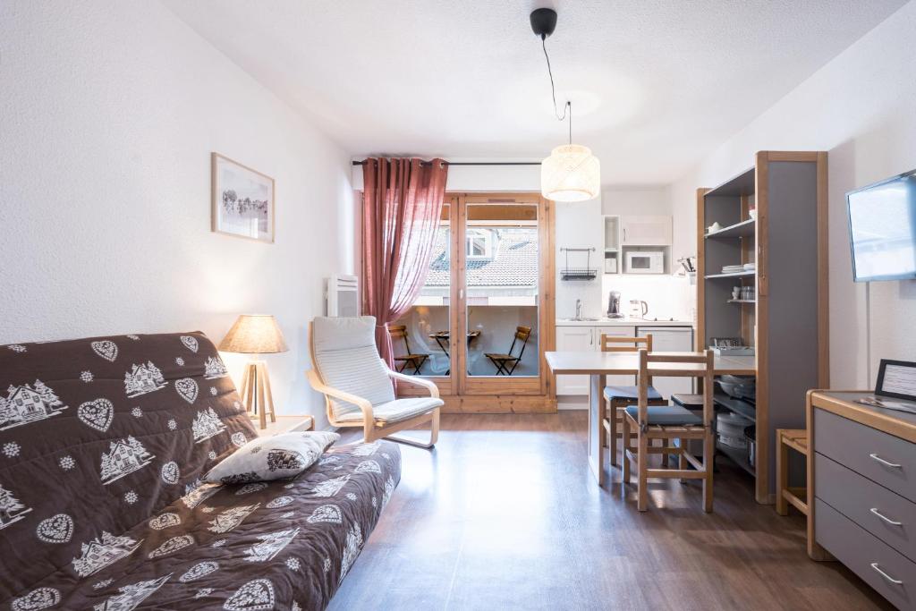 una sala de estar con un sofá y una mesa en Studio Grand Chalet, en Brides-les-Bains