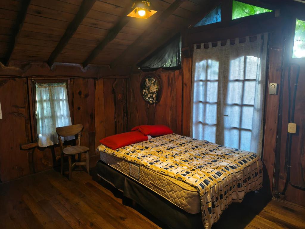 a bedroom with a bed in a room with wooden walls at Cabaña Punta Mogotes in Mar del Plata