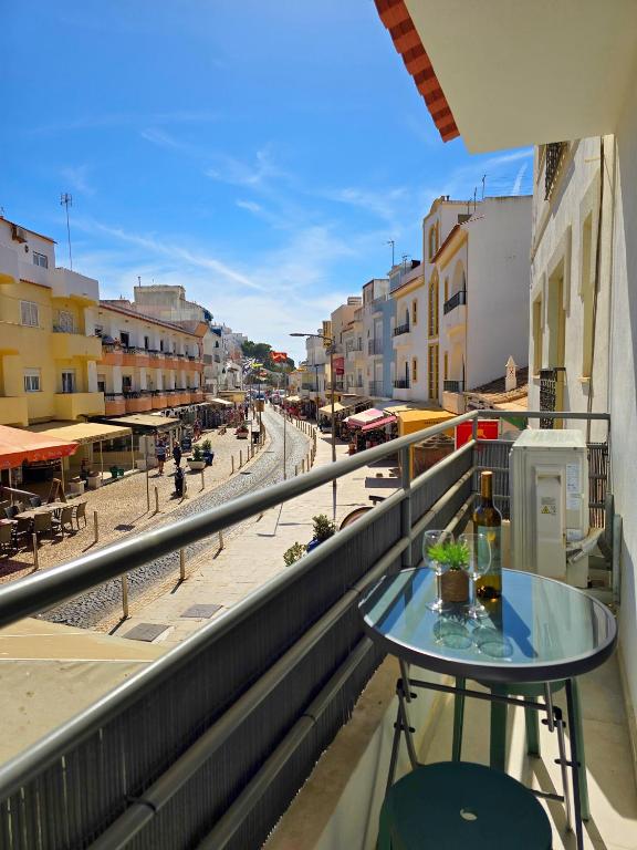 a table on a balcony with a view of a street at CASA SAFIA - Beach & Center - AC, WiFi in Carvoeiro