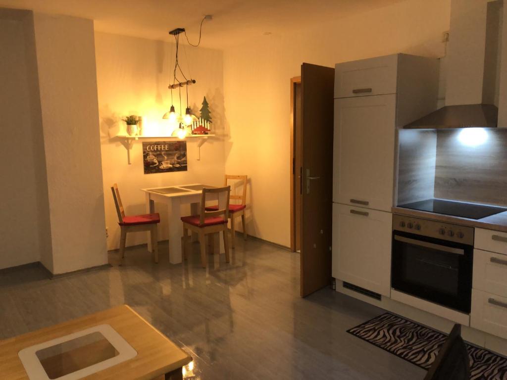 a kitchen and dining room with a table and a kitchen and a kitchen at Moderne Vollmöblierte Wohnung in Zwickau