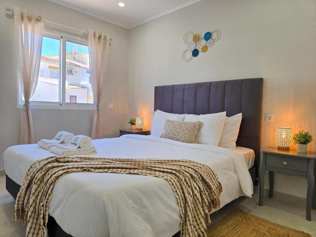 a bedroom with a large bed and a window at Casa Safia - Beach & Center 200m, AC, WiFi in Carvoeiro